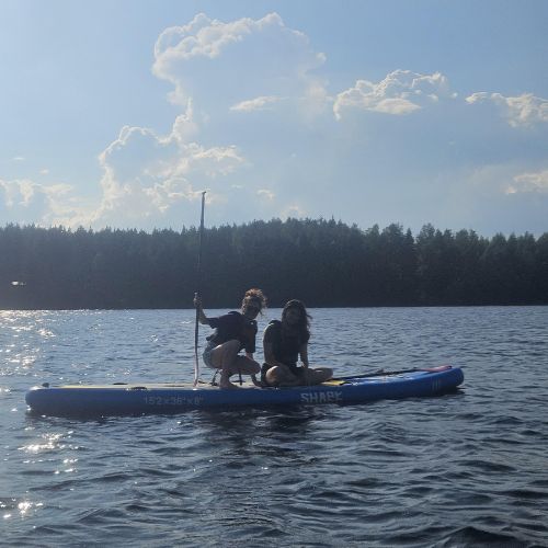 Two girls standing on a SUP-board and posing.